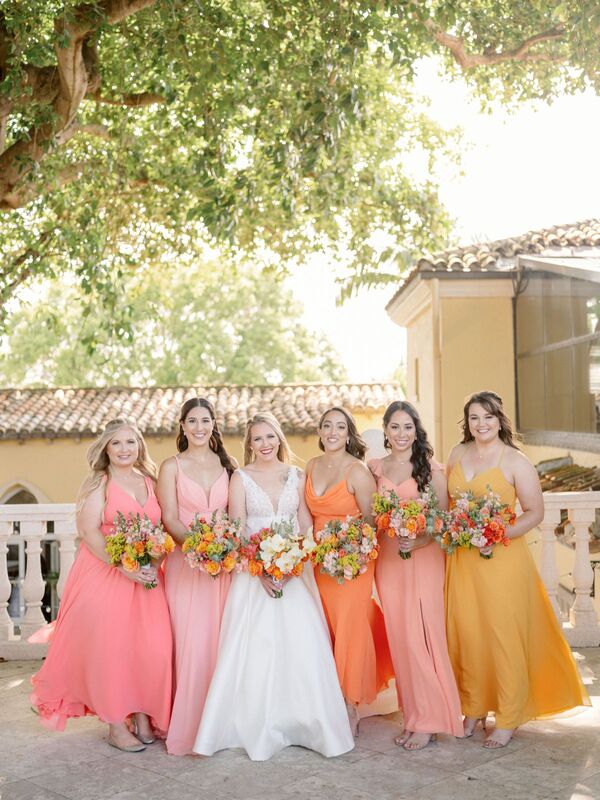bride with her bridal part in bright citrus colored dresses