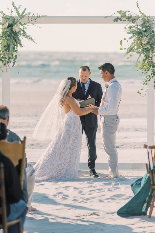 Bride and groom exchanging wedding vows on the beach at the Sunset Beach Resort on Siesta Key
