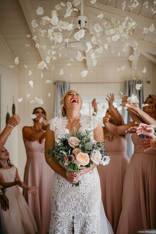Bridal party tossing rose petals over bride on her wedding day