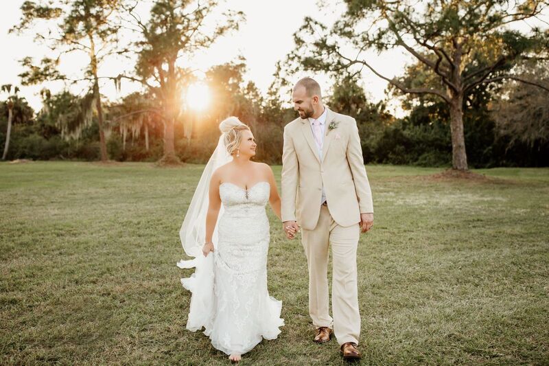 bide and groom walking across a field at their Venice Florida wedding