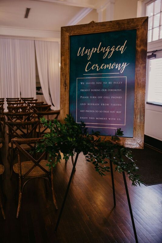 Hunter green and gold Unplugged Wedding sign at a wedding ceremony at The Orlo