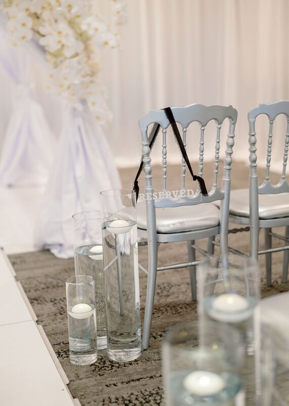 silver ballroom chairs with rows of floating candles for a wedding ceremony at Michael's on East in Sarasota