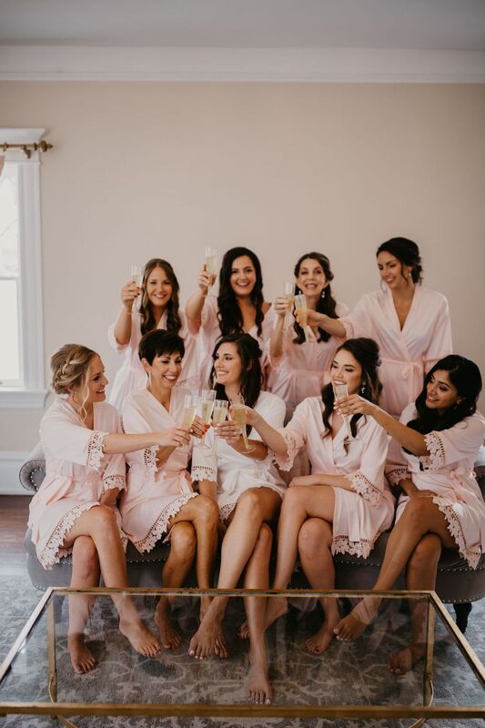 Wedding party in matching robes toasting with champagne 