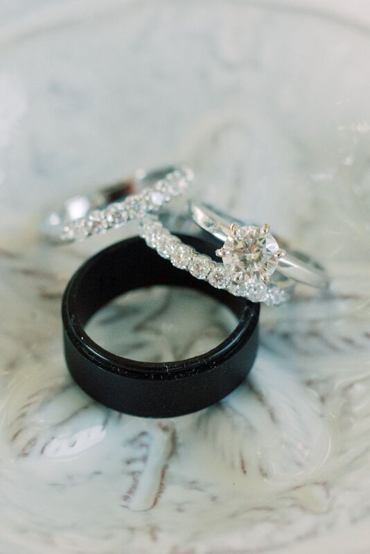 Black grooms wedding band with delicate diamond wedding bands for his bride