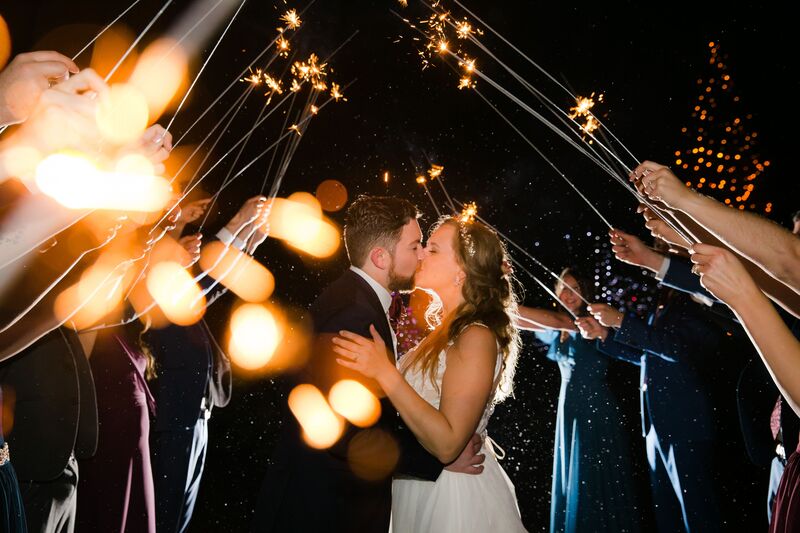 bride and groom making a grand exit surrounded by wedding guests with sparklers