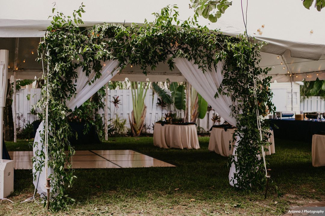 lush greenery marking the entrance to a tented wedding reception at Sunset Beach Resort