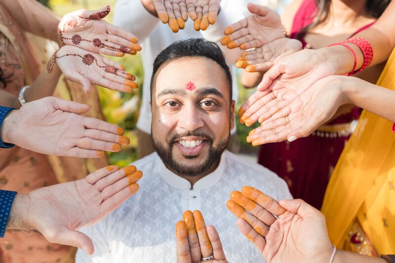 South Asian groom covered with tumeric during a Haldi ceremony at the Ritz Carlton Sarasota