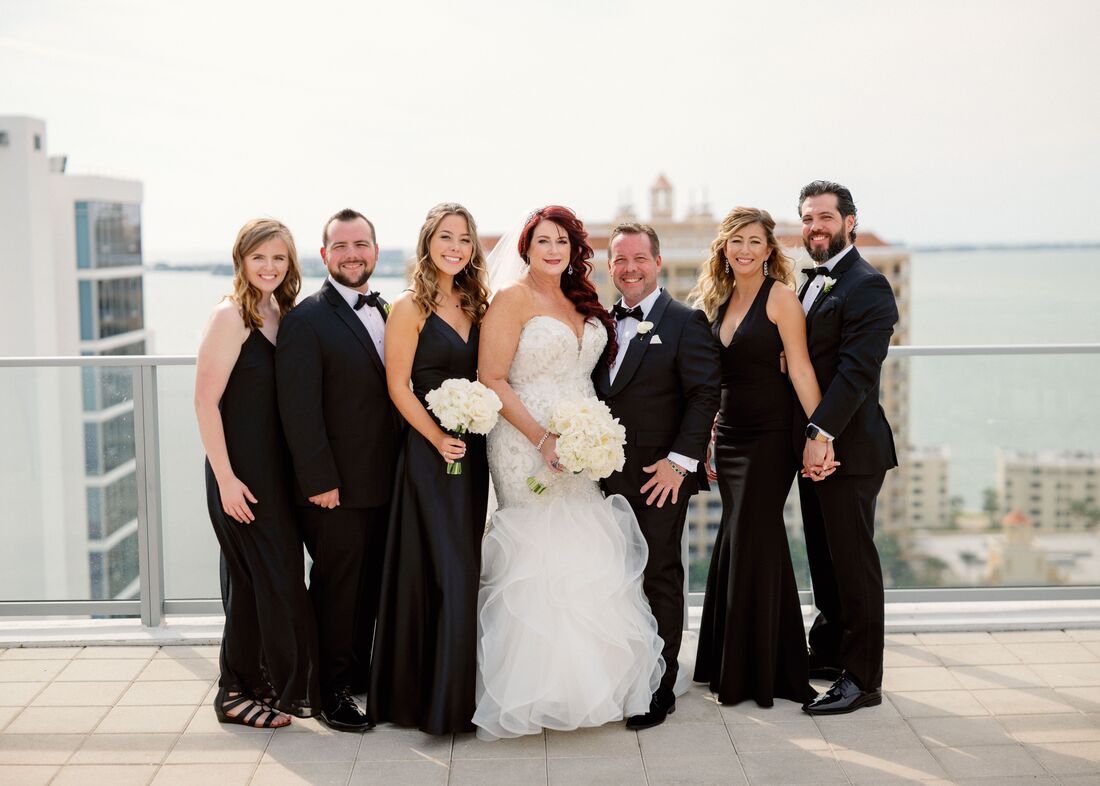 bride, groom and wedding party in black tie attire on the rooftop of the Westin Sarasota