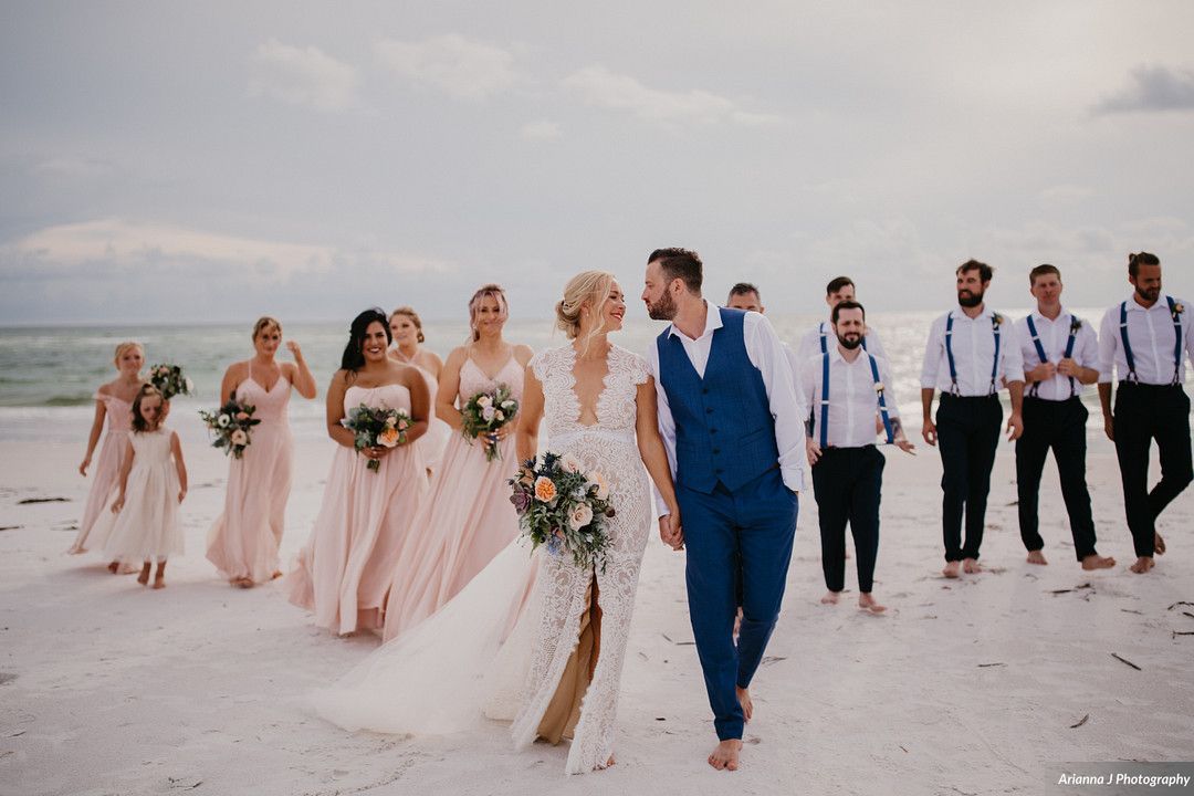 newlywed couple and wedding party walking on the beach at Siesta Key
