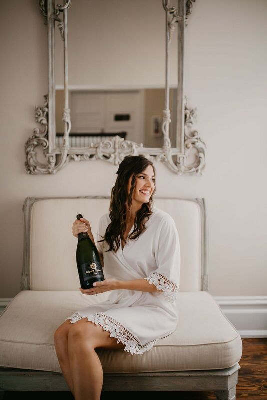 Bride in a shabby chic ready room with a bottle of champagne