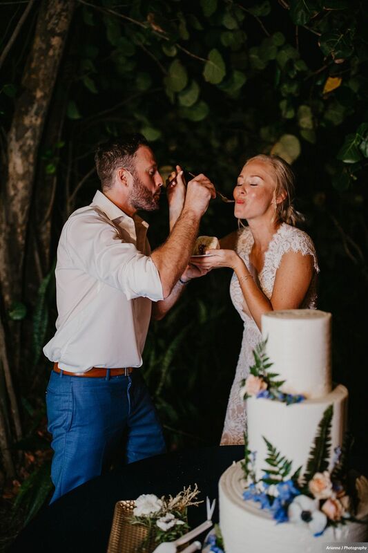 Bride and groom feeding each other cake at their Sunset Beach wedding