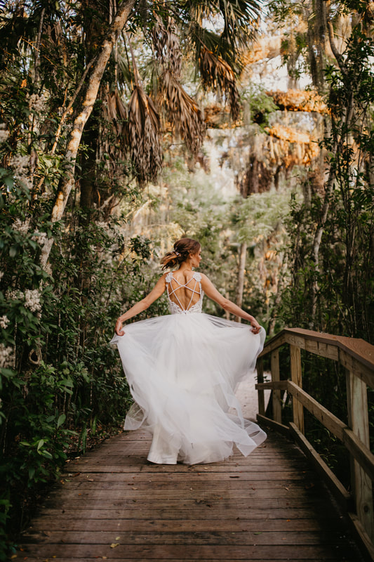 Sarasota bride showing off her wedding gown walking through Marie Selby Botanical Gardens