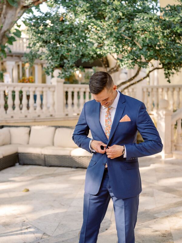 Groom in a blue suit with citrus colored tie and pocket square