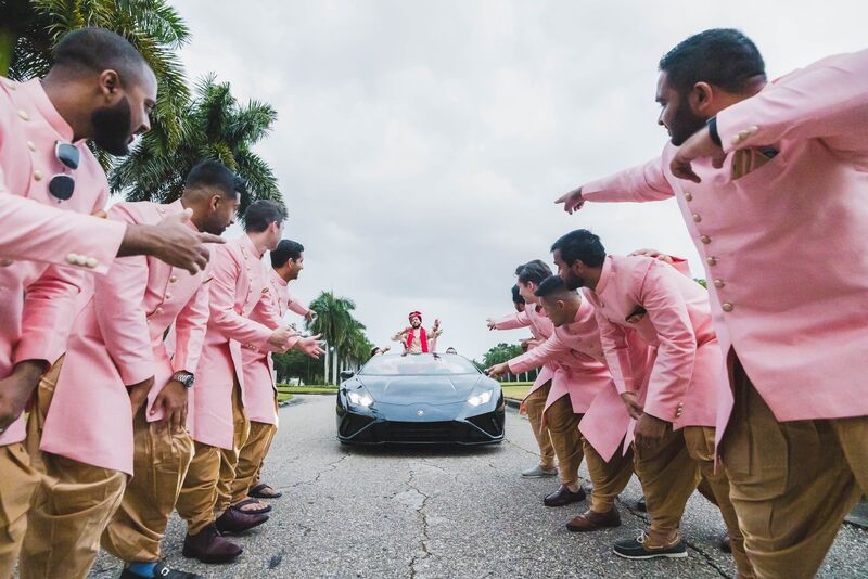 Broomsmen welcoming a groom to his barrat arriving in a Lamborghini