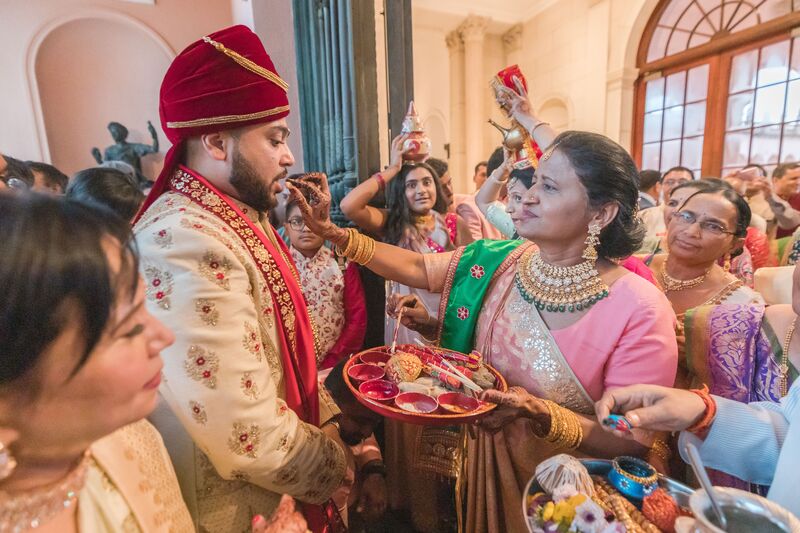 South Asian bride's family welcomeing the groom in a traditional Indian ceremony