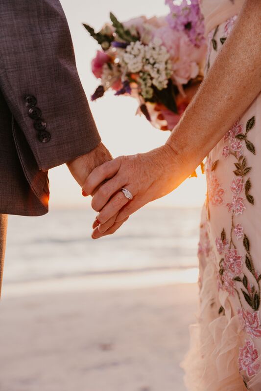 closeup of bride and groom holding hands on Siesta Key Beach