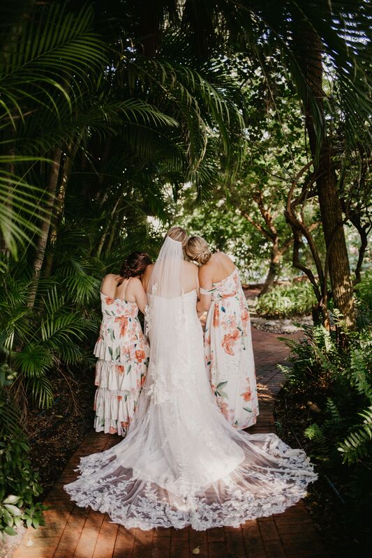 bride and bridesmaids walking in a tropical garden at the Longboat Island Chapel