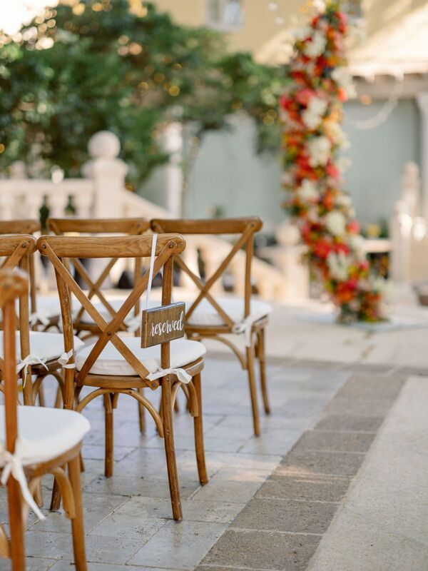elegant wooden chairs for an outdoor wedding ceremony in the courtyard of The Addison in Boca Raton