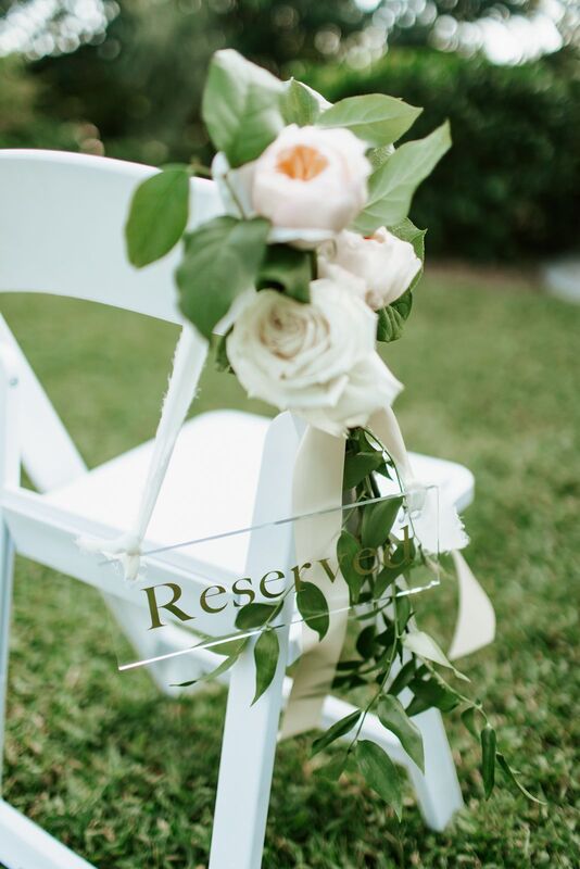 white garden chair with reserved sign and white flowers at Selby Gardens wedding ceremony