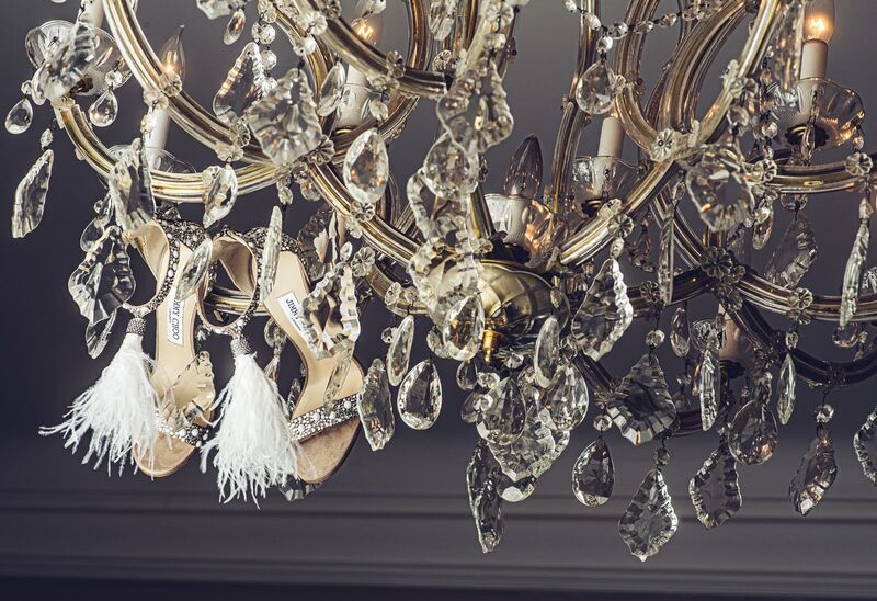 brides rhinestone wedding shoes hanging in a crystal chandelier