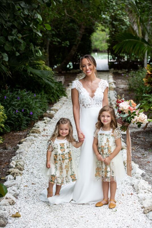 bride with flower girls in hand embroidered dresses