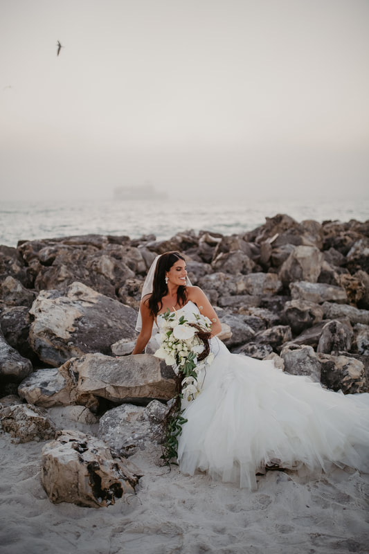 Art photo of a bride laying on the rock on Clearwater Beach