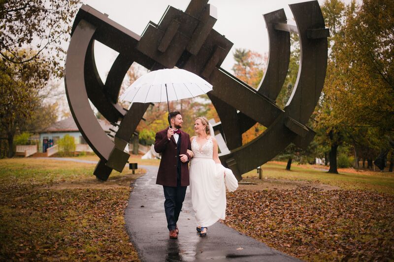 bride and groom in front of a metal sculpture at the Pyramid Hill Sculpture Park