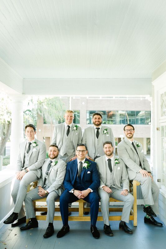 Groom and groomsmen posing for photos on the porch of the Orlo in Tampa