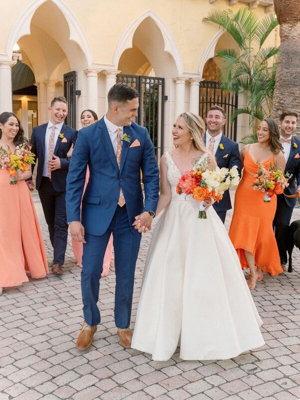Bride and groom with wedding part in brightly colored attire