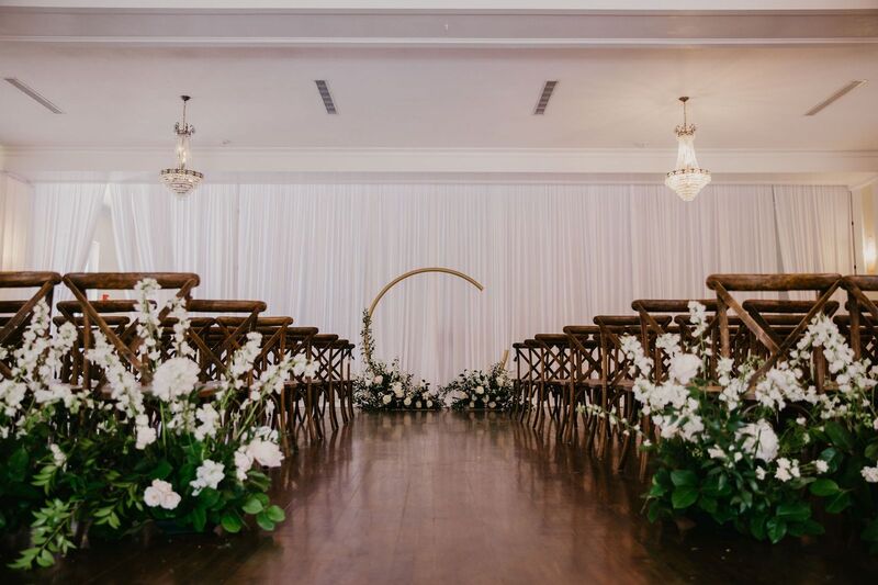 Indoor wedding ceremony at The Orlo set with a modern Moon Gate wedding structure 