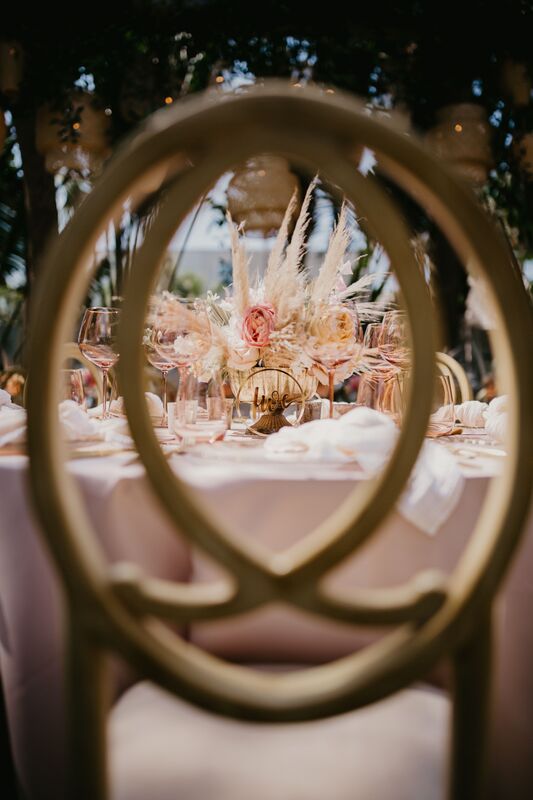 view of a beach-boho table scape taken through the back of the reception chair