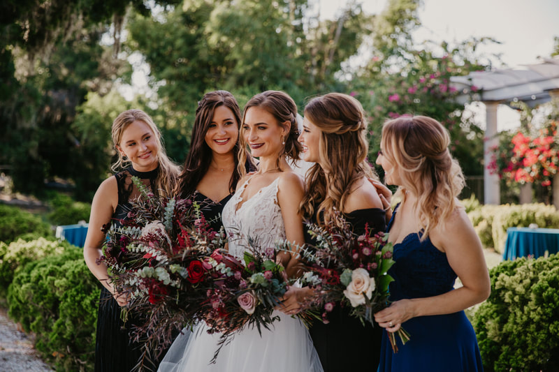 bride with bridal party holding luxurious jewel tone bouquets