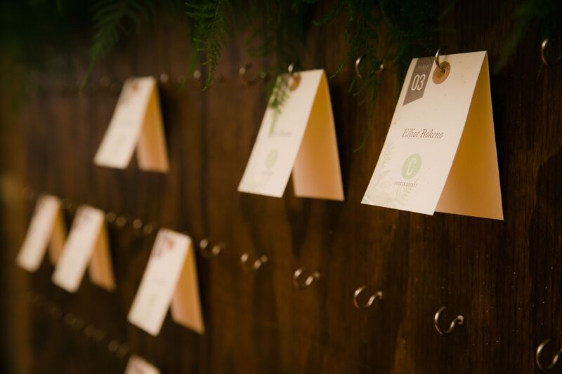 Unique wooden escort card board with gold tools and hanging cards