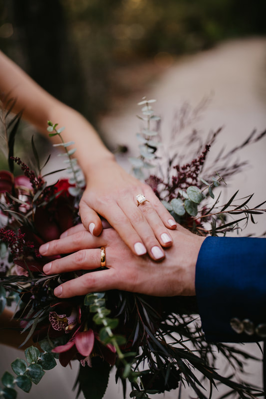 close up photo of bride and grooms hands with new wedding rings