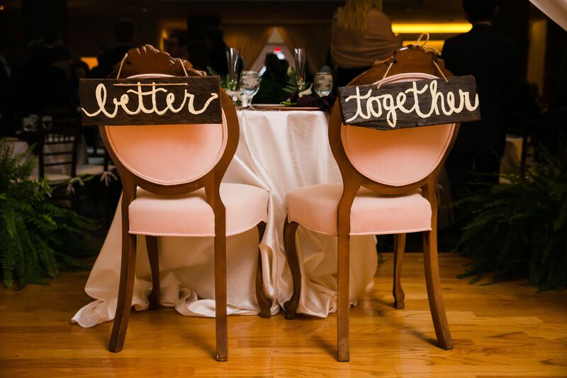 bride and groom's chairs with signs reading Better  and Together