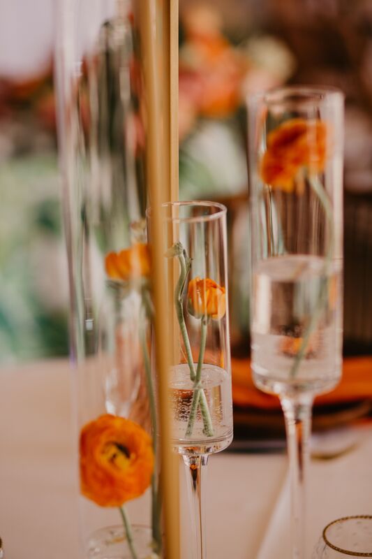 modern touches with orange flowers added to a tropical inspired wedding reception