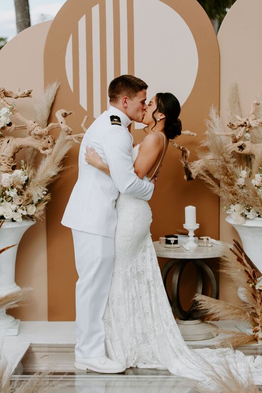 Groom in Navy Dress White Uniform kissing his bride