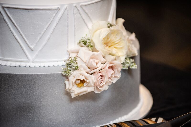White wedding cake with bold geometric design and  soft white flowers