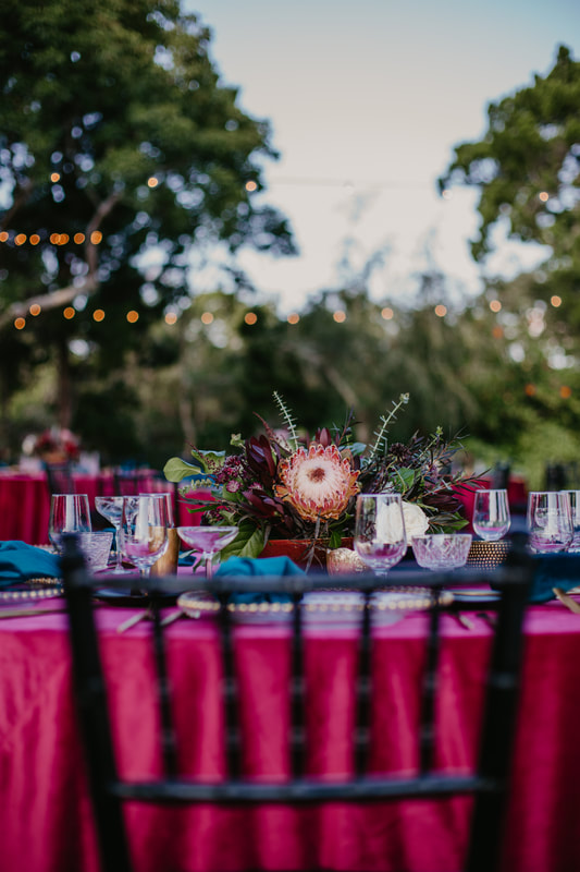tablescape of rich jewel tones at Sarasota wedding reception at Marie Selby Gardens