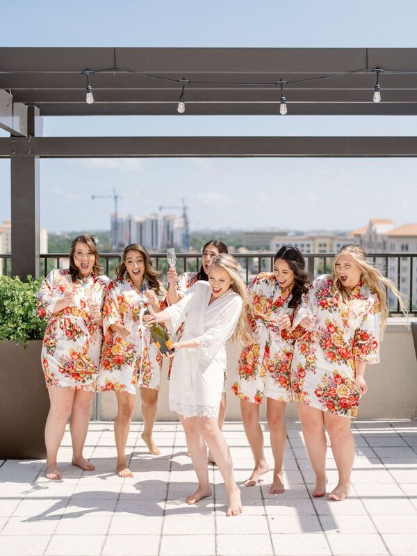bride and wedding party in matching robes with punchy citrus colors