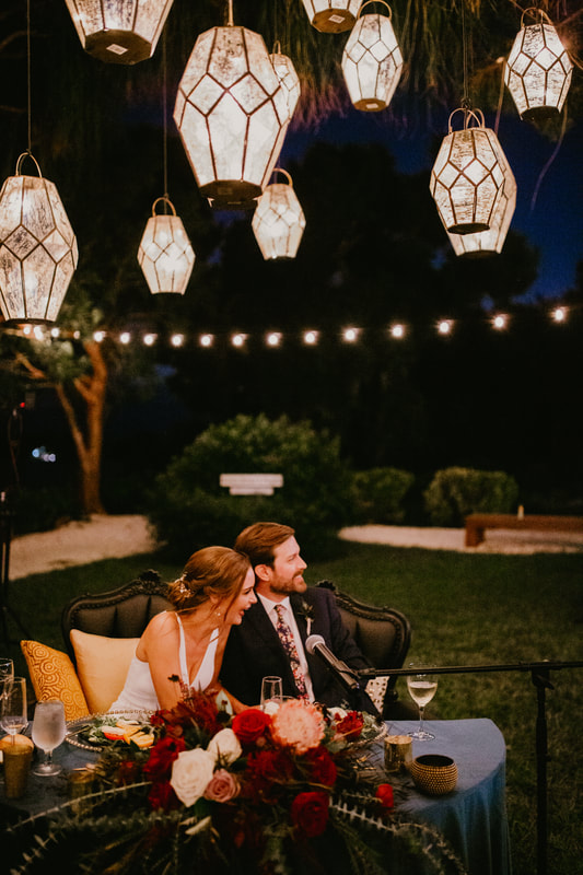 Sarasota bride and groom at sweetheart table under hanging lanterns