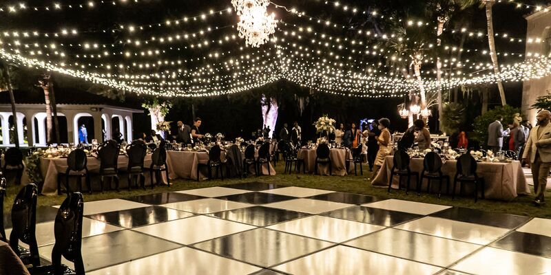 black and white dance floor under a canopy of twinkle lights and crystal chandeliers at Powell Crosley Estate