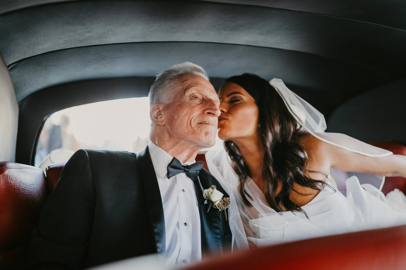Bride riding in a vintage Rolls Royce with her father