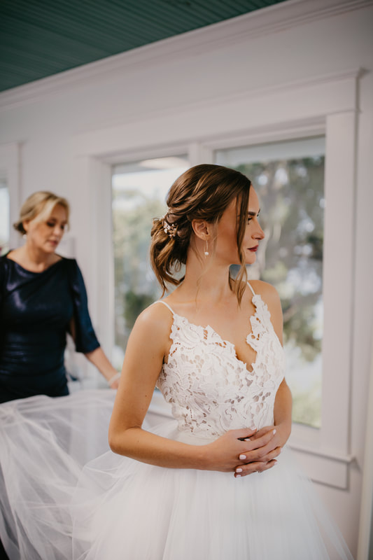 woman fluffing the back of a brides dress