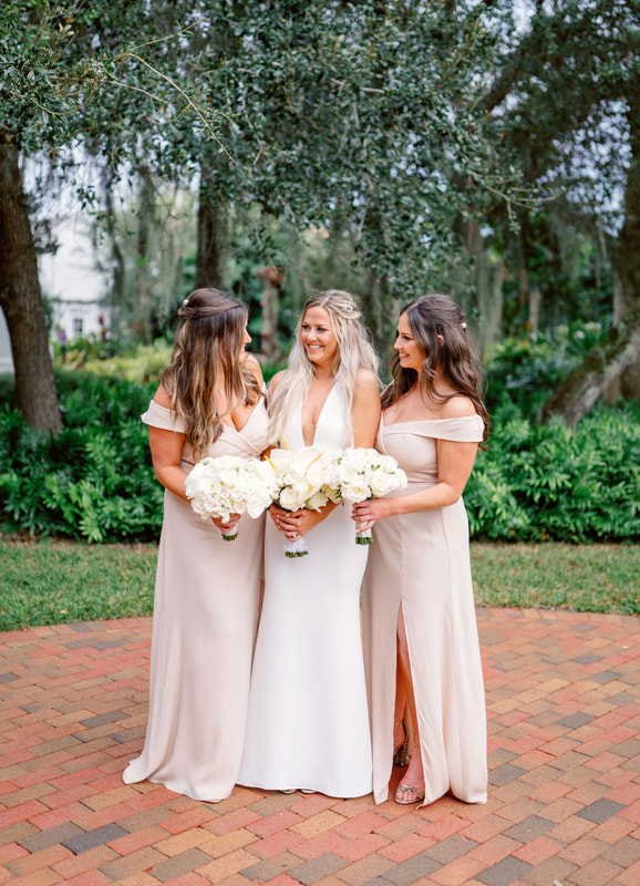 bride and bridesmaids holding white bouquets