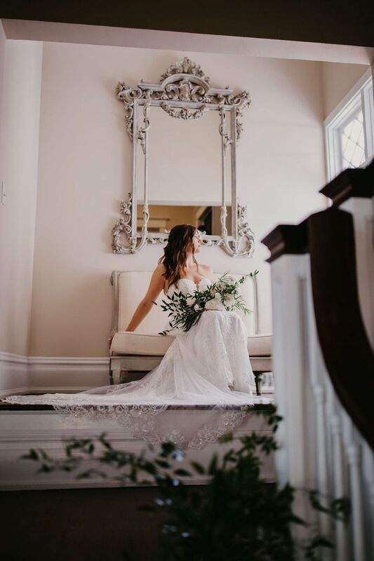 Bride holding bridal bouquet while reclining on a vintage loveseat at The Orlo in Tampa