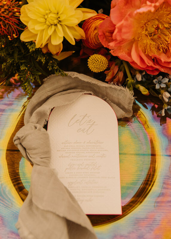 irredecent charger plate with a knotted napkin and a custom menu cards