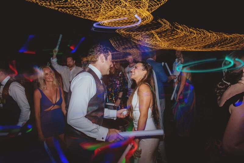 bride and groom dancing surrounded by colorful lighting