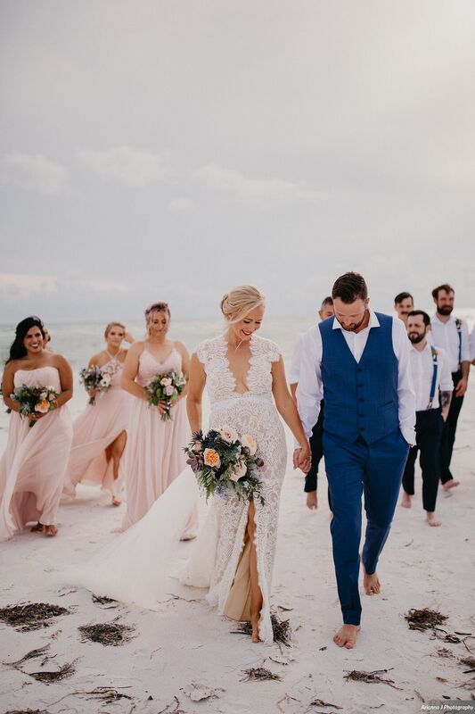 bride and groom walking on Siesta Key beach with their wedding party