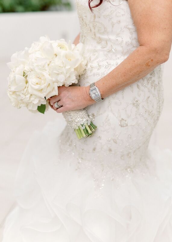 bride's hand holding her white bridal bouquet